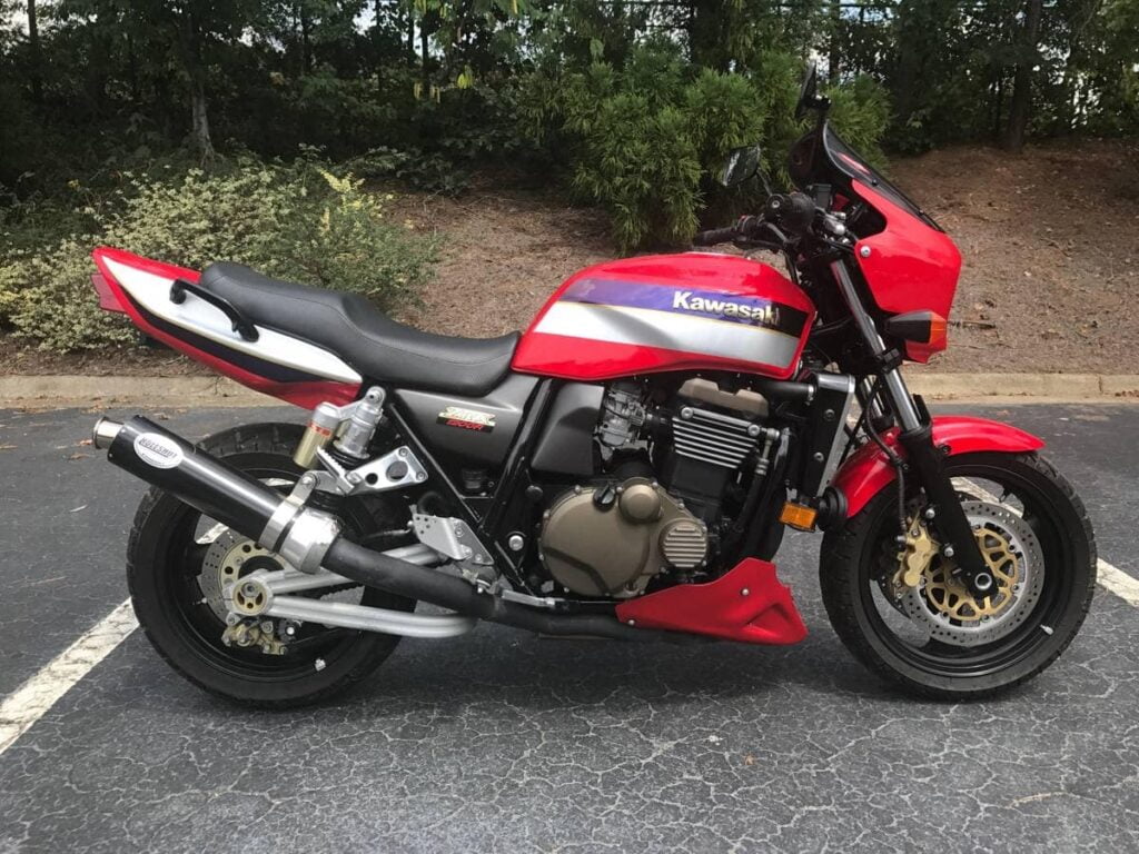 Affordable classic motorcycle the Kawasaki ZRX1200R in red, with kerker exhaust, in parking space