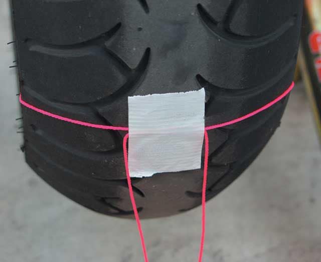 Check motorcycle alignment with string tape onto tyre