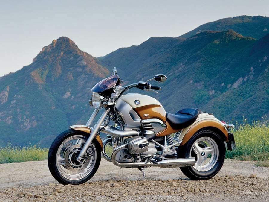 Ivory/Peach BMW R1200C on a dirt road with mountains in the background