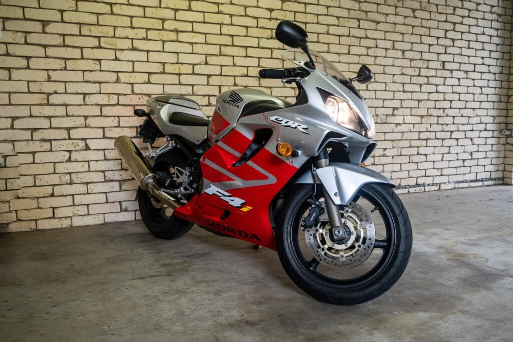 Photo of my CBR600F4i against a brick wall with headlights on