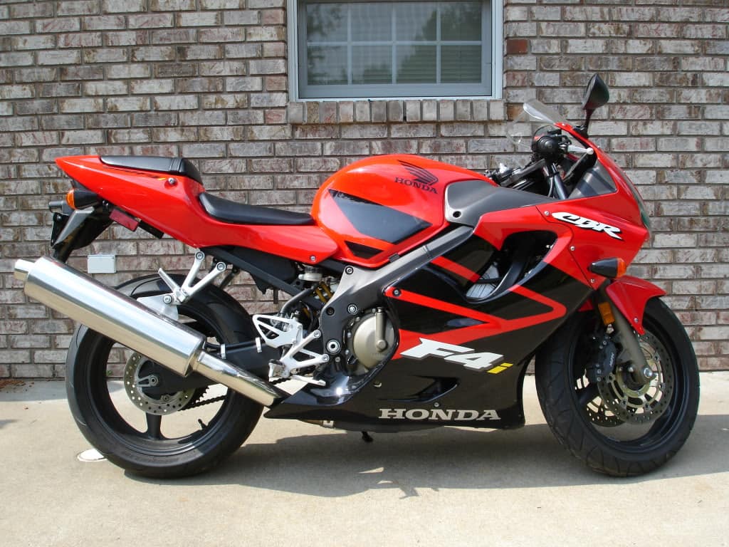 Red and black Honda CBR600F4i against brick wall