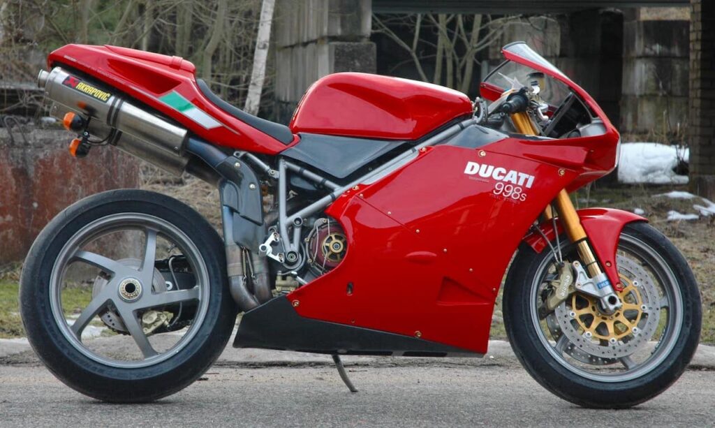The Ducati 998S with lightweight Marchesini wheels and gold Öhlins front forks, trees in background.