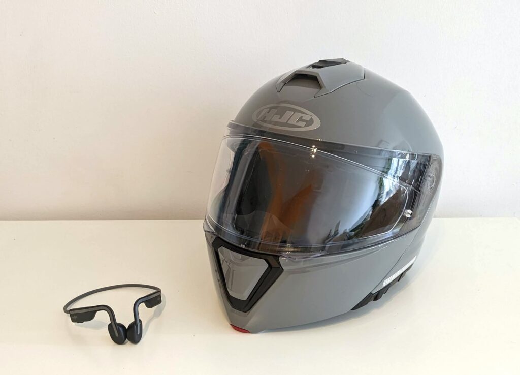 Shokz OpenRun bone conduction headphones and HJC i90 motorcycle helmet