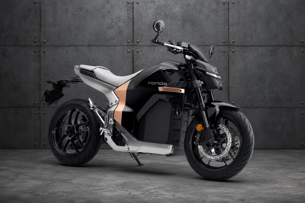 So, Is the Honda WN7 Any Good? 1 Honda WN7 electric motorcycle in front of a riveted steel wall