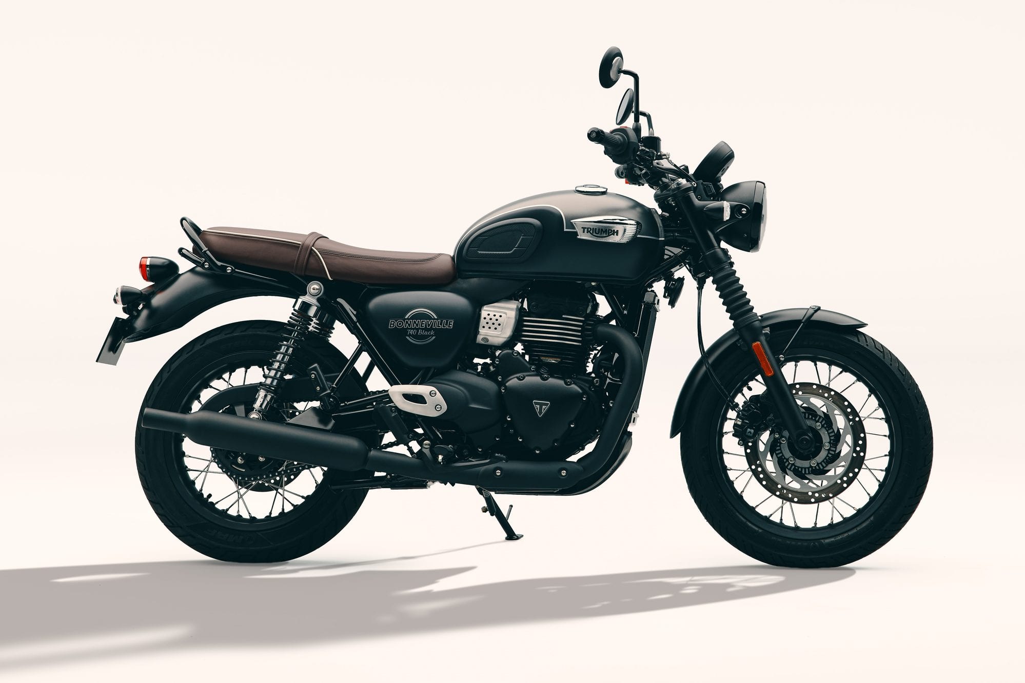 Triumph 400 Model Guide 23 2027 Triumph Bonneville T40 Black with a brown bench seat, parked in a right-side view