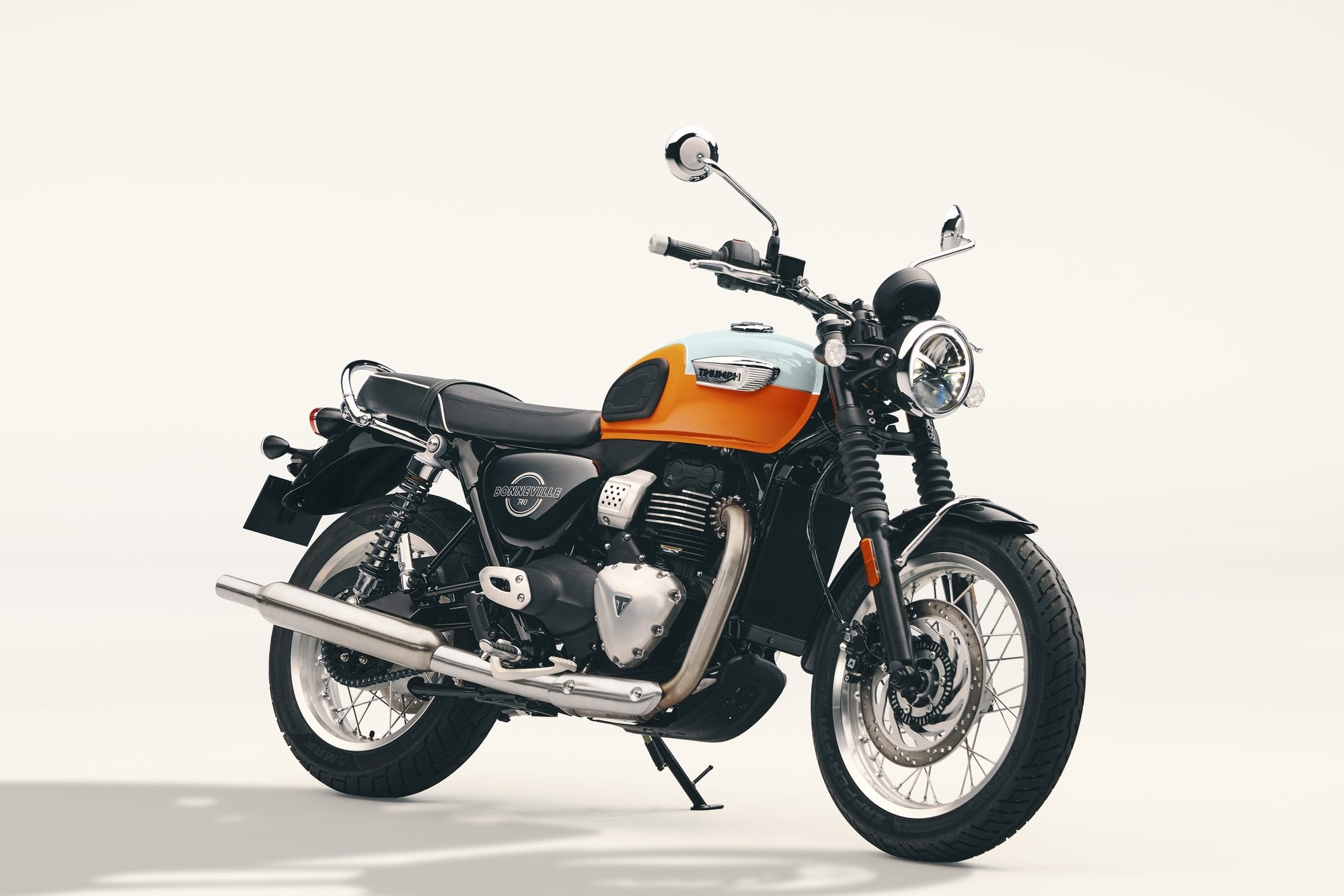 Triumph 400 Model Guide 21 2027 Triumph Bonneville T40 in Meriden Blue and Tangerine Orange, parked in a front-right three-quarter view